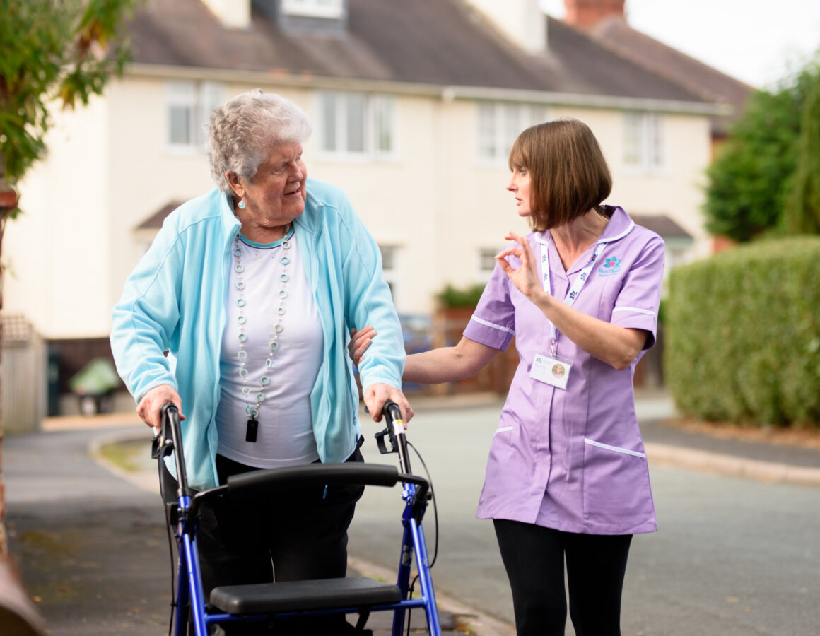 Carer and client out for a walk with rollator