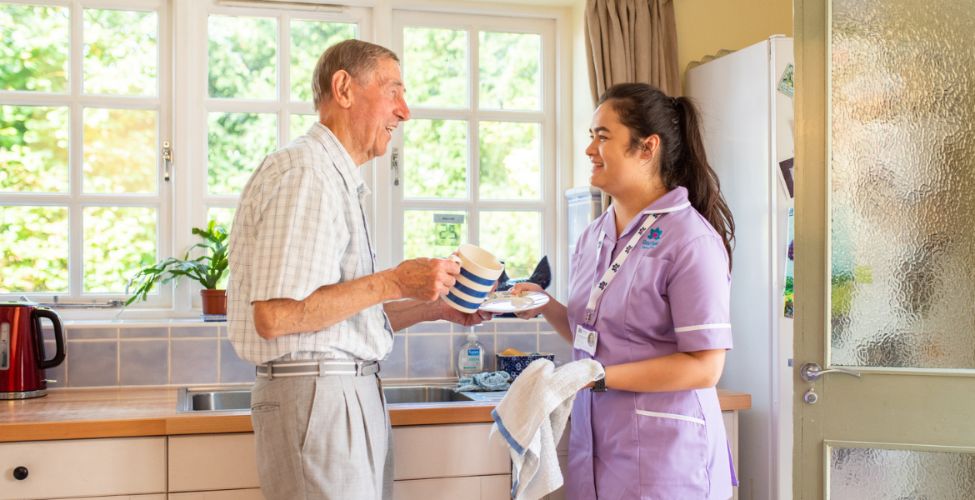 client and carer doing the dishes