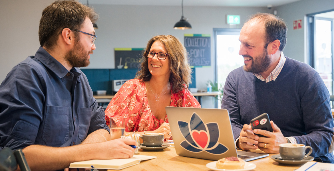 three people sat around a table talking about franchising