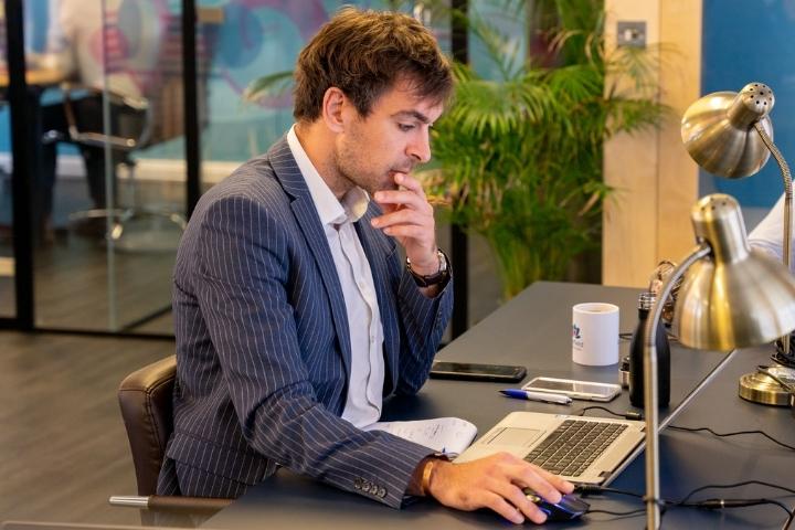 An office owrker looking at his latop in deep thought at Radfield Home Care National Office