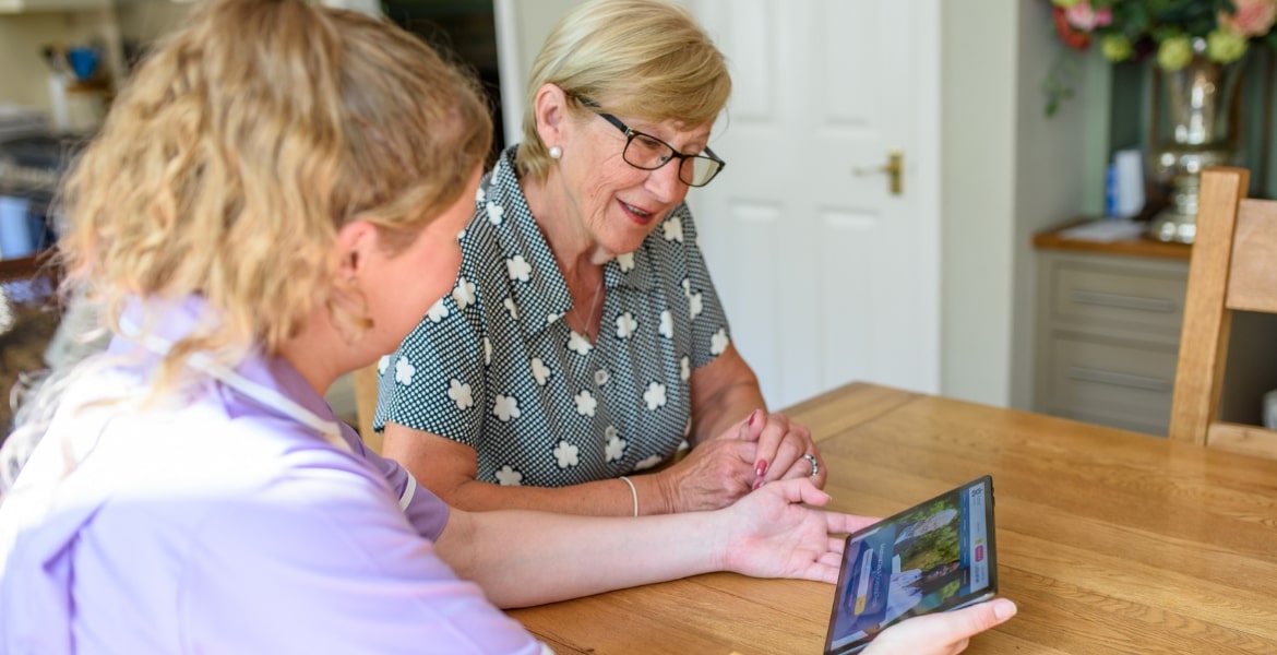 Care professional and patient on tablet | Radfield Home Care