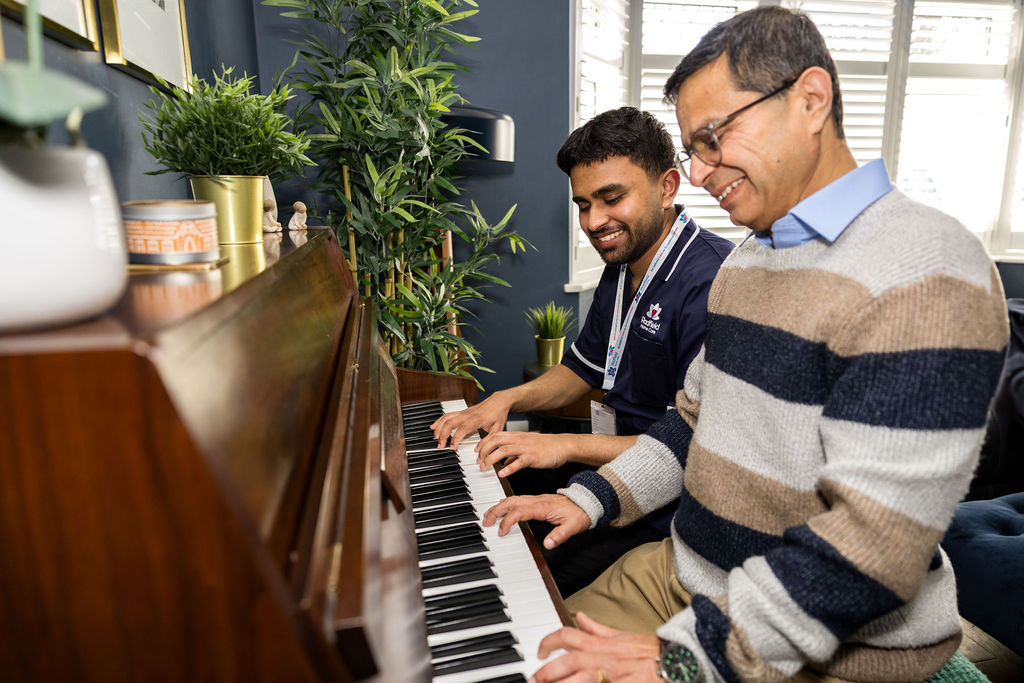 A Radfield Home Care Care Professional and client playing the piano