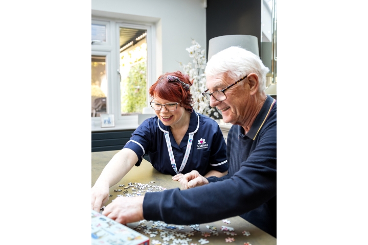 Client and Care professional doing a puzzle