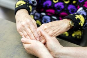 Hands gently held, showing comfort and support.