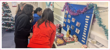 A photo of people looking at photographs at the Radfield Home Care Epsom & Leatherhead Christmas party