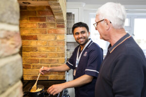 loved one doesn’t want to move into a care home. Care Professional cooking for a client 