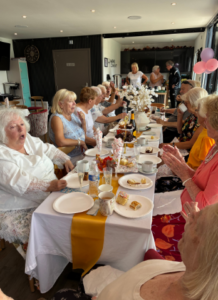 The image shows community friendship events across Liverpool taking place, with a few older people eating a meal together