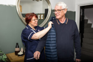 Care Professional helping a Client dress