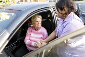 Care Professional helping a client get out of her car