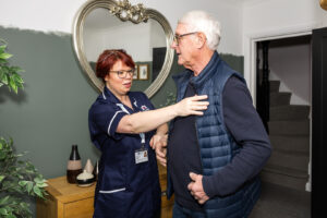 Image of Care Professional helping a client dress