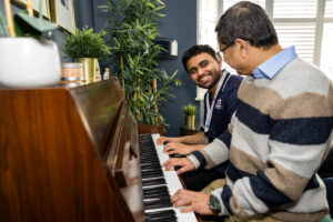 Image of Care Professional playing piano with a client