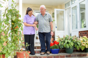 A client walking with an older gentleman, giving his family carer some respite in Derby